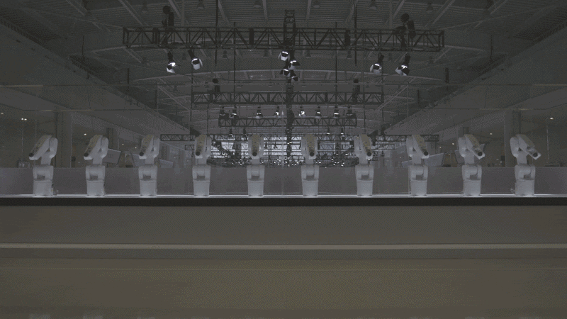 Manus — group of robotic arms responding to a person walking by